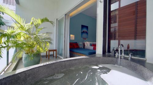 a bathroom with a large bath tub with water at Rambutan Resort – Phnom Penh in Phnom Penh