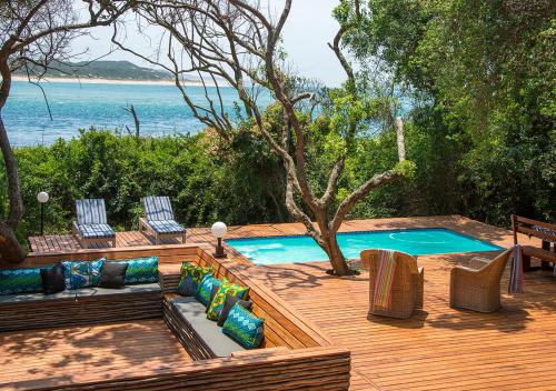een achtertuin met een zwembad en twee stoelen en een terras bij Cabo Beach Villas in Santa Maria