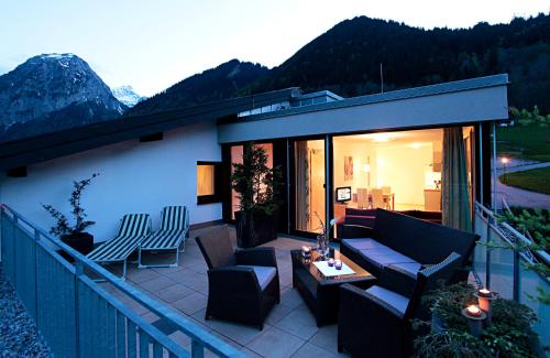 eine Terrasse mit einem Sofa und Stühlen auf dem Balkon in der Unterkunft Bergkristall in Brand