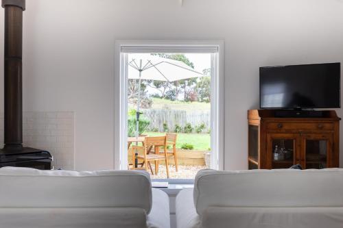 ein Wohnzimmer mit einem Sofa und einem Tisch mit einem Sonnenschirm in der Unterkunft A Cottage In Richmond in Richmond