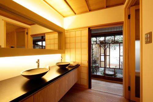 une salle de bain avec deux lavabos sur un comptoir dans l'établissement Tawara-an, à Kyoto