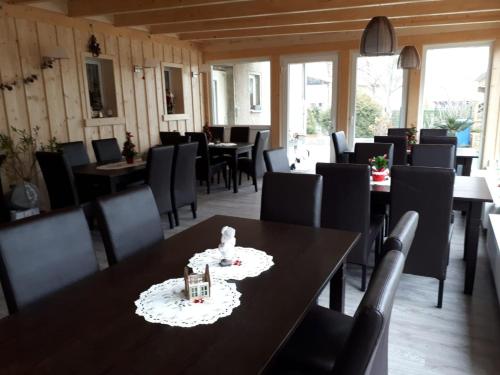 a dining room with a table and chairs and windows at Pension Sommerfrische in Nebra