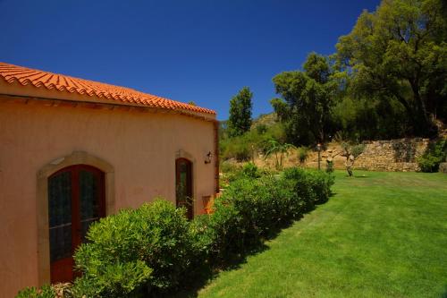 an orange building with a yard with green grass at B&B Le Ginestre in Cefalù