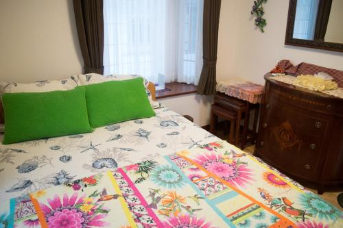 een bed met een kleurrijke quilt erop bij La Fata in Uruma