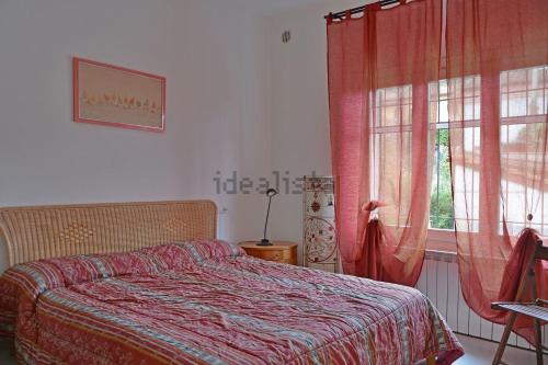 インペリアにあるCasa Fortunaのベッドルーム1室(ベッド1台付)、赤いカーテン付きの窓が備わります。