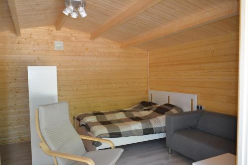 een slaapkamer met een bed, een bank en een stoel bij Camping-Aller-Leine-Tal in Engehausen