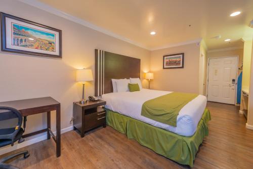 a hotel room with a bed and a desk and a bed at Ocean Pacific Lodge in Santa Cruz