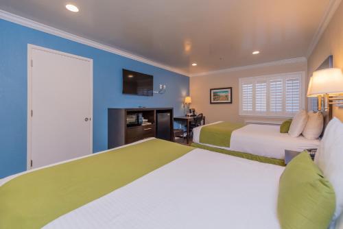 two beds in a room with blue walls at Ocean Pacific Lodge in Santa Cruz