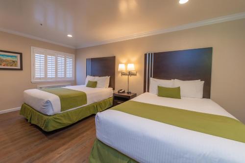 a hotel room with two beds and a window at Ocean Pacific Lodge in Santa Cruz