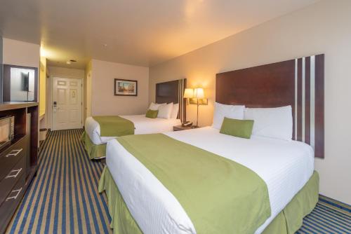 a hotel room with two beds and a flat screen tv at Ocean Pacific Lodge in Santa Cruz