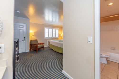 a hotel room with a bed and a bathroom at Ocean Pacific Lodge in Santa Cruz