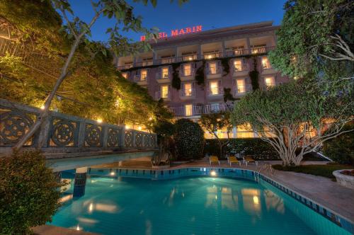 a swimming pool in front of a hotel at night at Grande Albergo Marin in Lignano Sabbiadoro