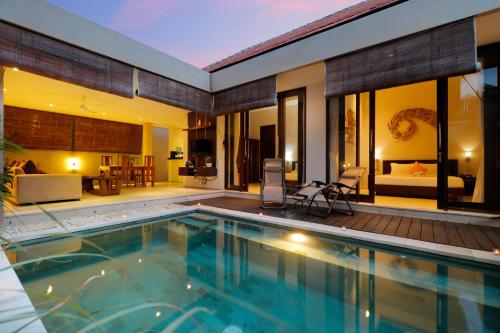 a house with a swimming pool and a living room at Sudha Villa Bali Baik-Baik in Seminyak