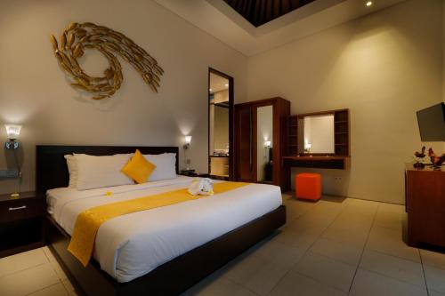 a bedroom with a large bed and a television at Sudha Villa Bali Baik-Baik in Seminyak