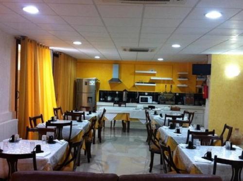 a restaurant with tables and chairs and a kitchen at OUMAYA SAFA in Alger