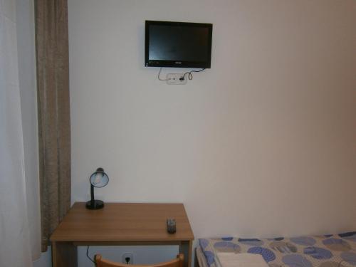 Habitación con cama y TV en la pared. en Fanni Budapest Guesthouse, en Budapest