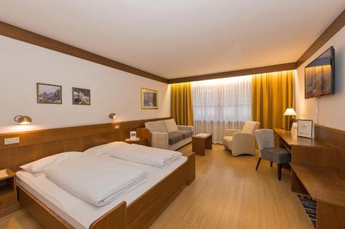 a hotel room with a bed and a desk at Hotel Mondschein in Sesto