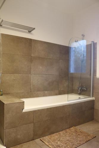 a bathroom with a bath tub with a shower at Cabanas Jardim & Ria in Cabanas de Tavira