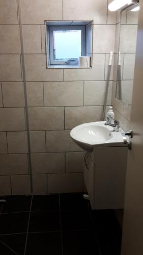 a bathroom with a sink and a window at Aarhus Syd Holiday Apartment in Beder