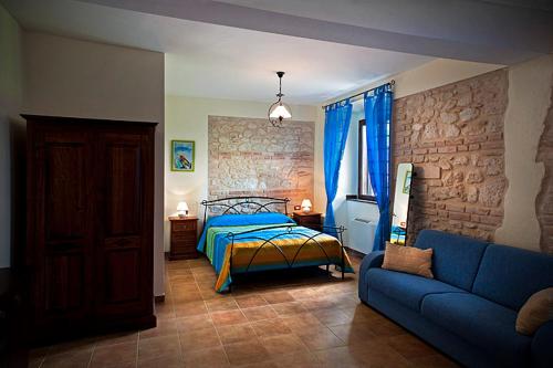 a bedroom with a bed and a blue couch at Il Poggio Dei Pettirossi in Pettorano sul Gizio