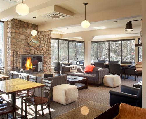 a lobby with a fireplace and tables and chairs at Hotel Aspen in Aspen