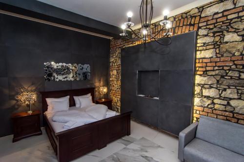 a bedroom with a bed and a brick wall at Boutique Hotel Annuska in Balatonfüred