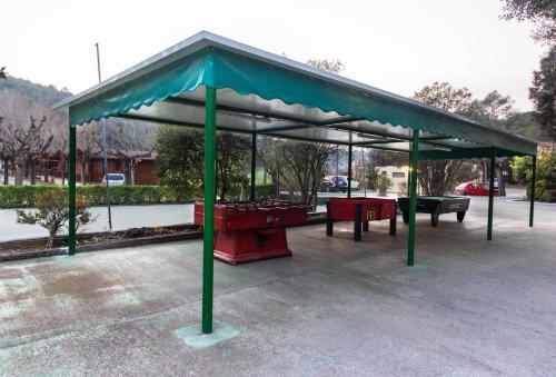 a pavilion with picnic tables in a parking lot at Camping Esponellà in Esponellá