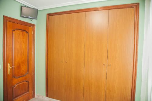 a closet with a wooden door in a room at Pensión Parque del Ebro in Logroño