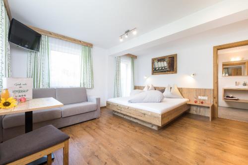 uma sala de estar com uma cama e um sofá em Hieserhof em Neustift im Stubaital