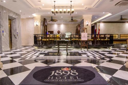 - un hall d'un hôtel avec une table et des chaises dans l'établissement 1898 Hotel Colonia En Las Filipinas, à Manille