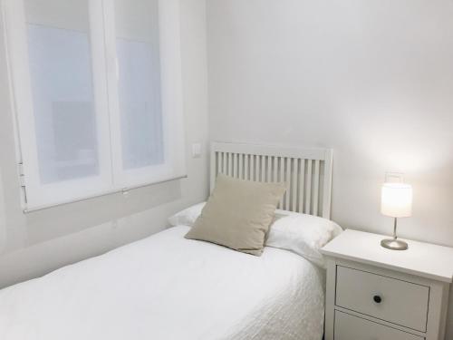biała sypialnia z łóżkiem i oknem w obiekcie Reina Victoria 46 w Madrycie