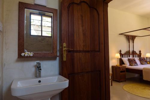 a bathroom with a sink and a window and a bed at Magic Beach Villa in Kiwengwa