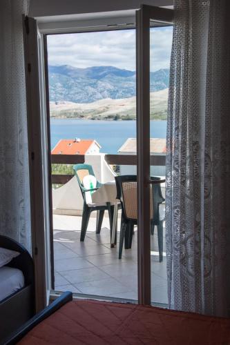 a view of a table and chairs from a sliding glass door at APARTMANI MARIJA LJUBICA in Pag