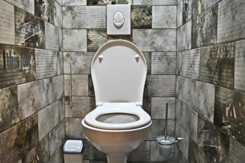 a toilet in a bathroom with a tiled wall at ApartLux 3 in Chernihiv