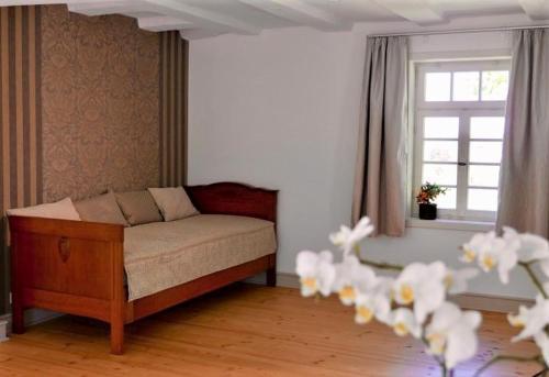 a living room with a bed and a window at Gutshof Schäferhaus in Frielendorf