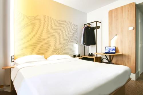 Un pat sau paturi într-o cameră la B&B HOTEL Reims Bezannes