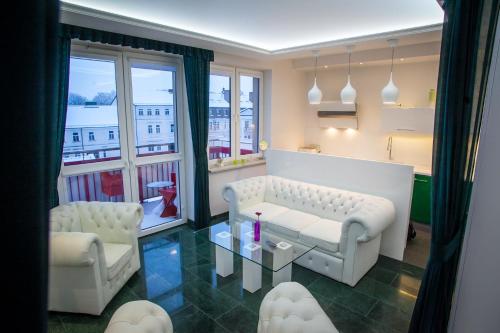 sala de estar con sofá, 2 sillas y mesa en Royal Apartment in City Centre, en Suwałki