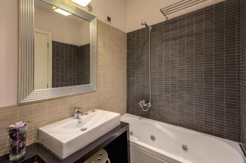 a bathroom with a sink and a tub and a mirror at 939 Hotel in Rome