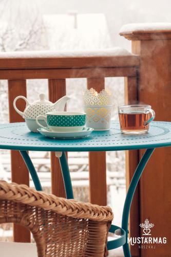 a blue table with bowls and cups on it at Mustármag Vendégház in Noszvaj