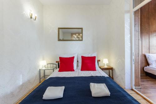 a bedroom with a large bed with red pillows at Little Home - Amber in Sopot