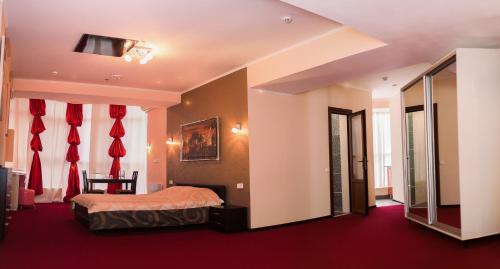 a bedroom with a bed and red curtains at Mark Plaza Hotel in Mykolaiv