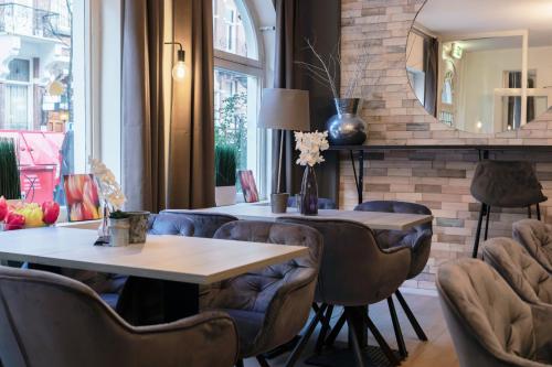 Habitación con mesa, sillas y espejo. en Quentin England Hotel, en Ámsterdam