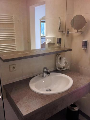 a bathroom with a sink and a mirror at Hotel Hochland in Leutasch