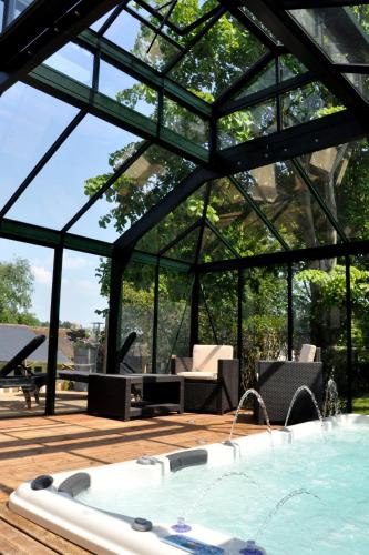 une baignoire jacuzzi sur une terrasse avec un pavillon dans l'établissement Hostellerie et SPA de la Vieille Ferme, à Criel-sur-Mer
