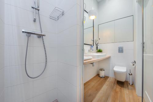 a white bathroom with a shower and a sink at Dwie Sosny z sauną, Sun & Snow in Ustronie Morskie