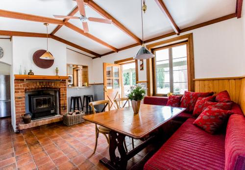 a living room with a red couch and a table at Grand Cru Estate Homestead in Springton