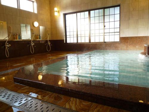 a large swimming pool in a building with a pool at Takanoya in Yuzawa