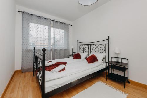 ワルシャワにあるShortStayPoland Krochmalna (B39)のベッドルーム1室(黒いベッド1台、白いシーツ、赤い枕付)