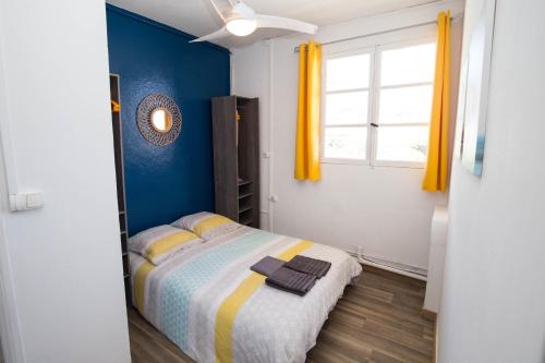 - une chambre avec un lit aux murs bleus et une fenêtre dans l'établissement T2 40m² Hypercentre, à Saint-Denis