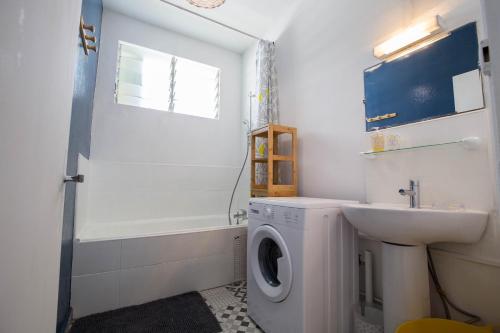 a bathroom with a washing machine and a sink at T2 40m² Hypercentre in Saint-Denis